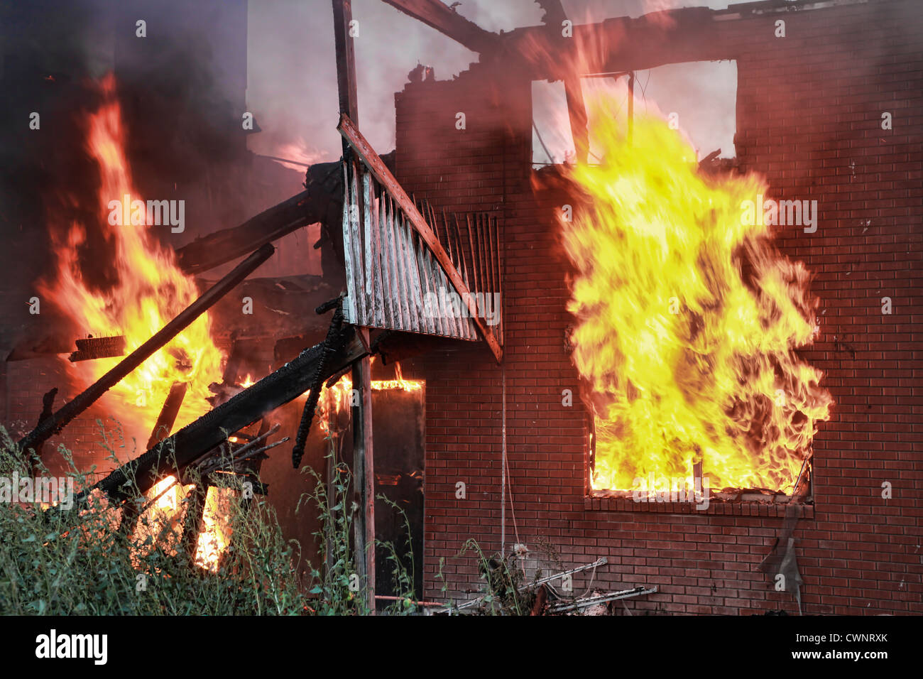 L'incendie d'une maison hors de contrôle comme leap flammes depuis les fenêtres. Banque D'Images