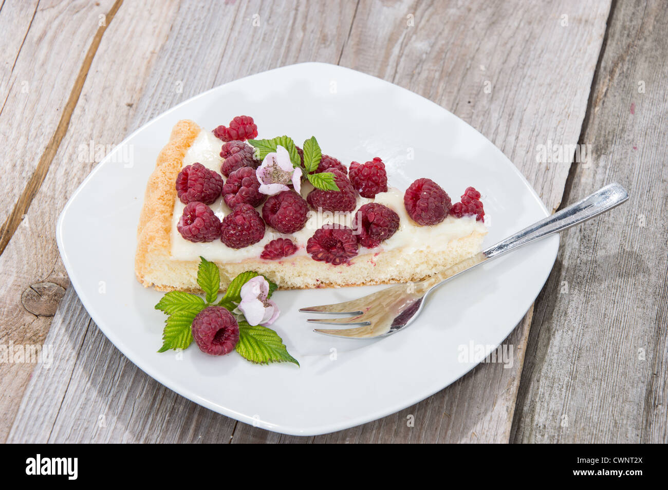 Morceau de gâteau à la framboise sur un plateau contre fond de bois Banque D'Images