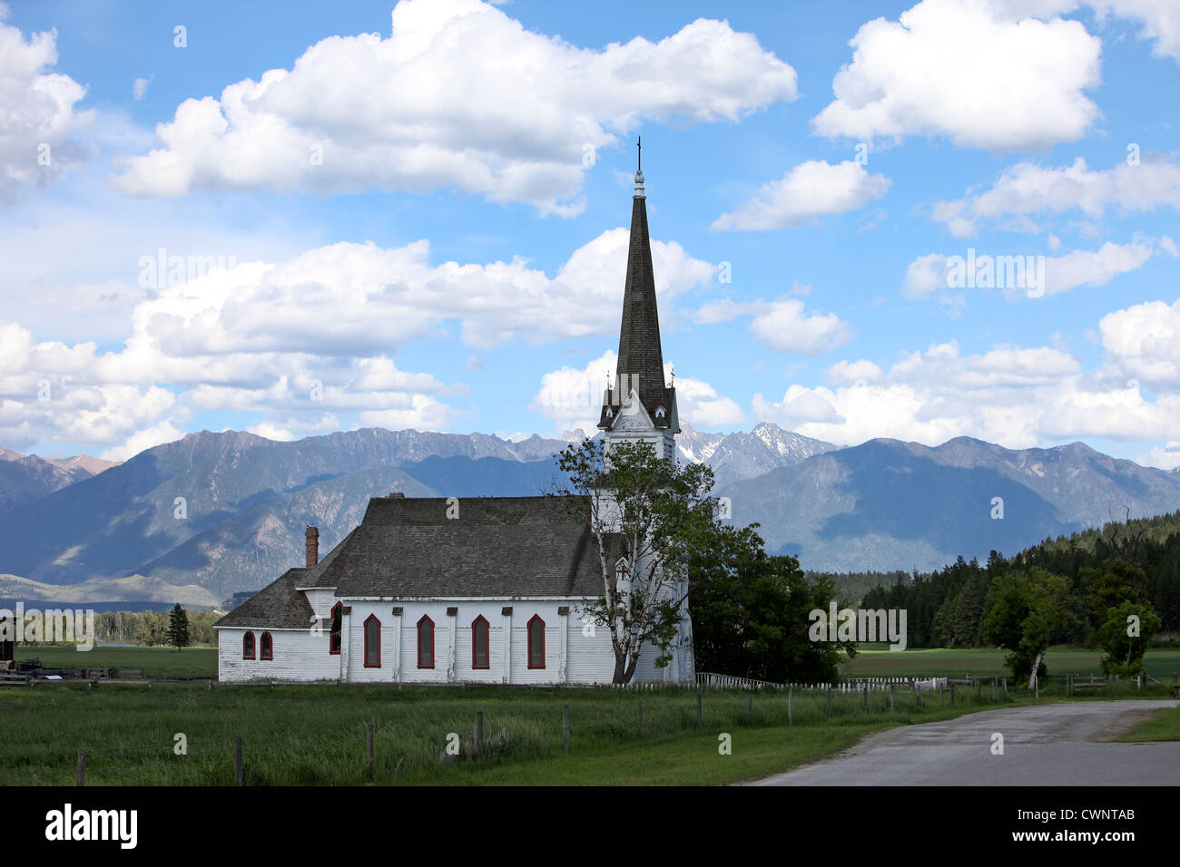 Eugene Mission Church, près de Cranbrook, Canada. Siège au milieu de verts pâturages avec des montagnes qui culminent dans l'arrière-plan. Banque D'Images