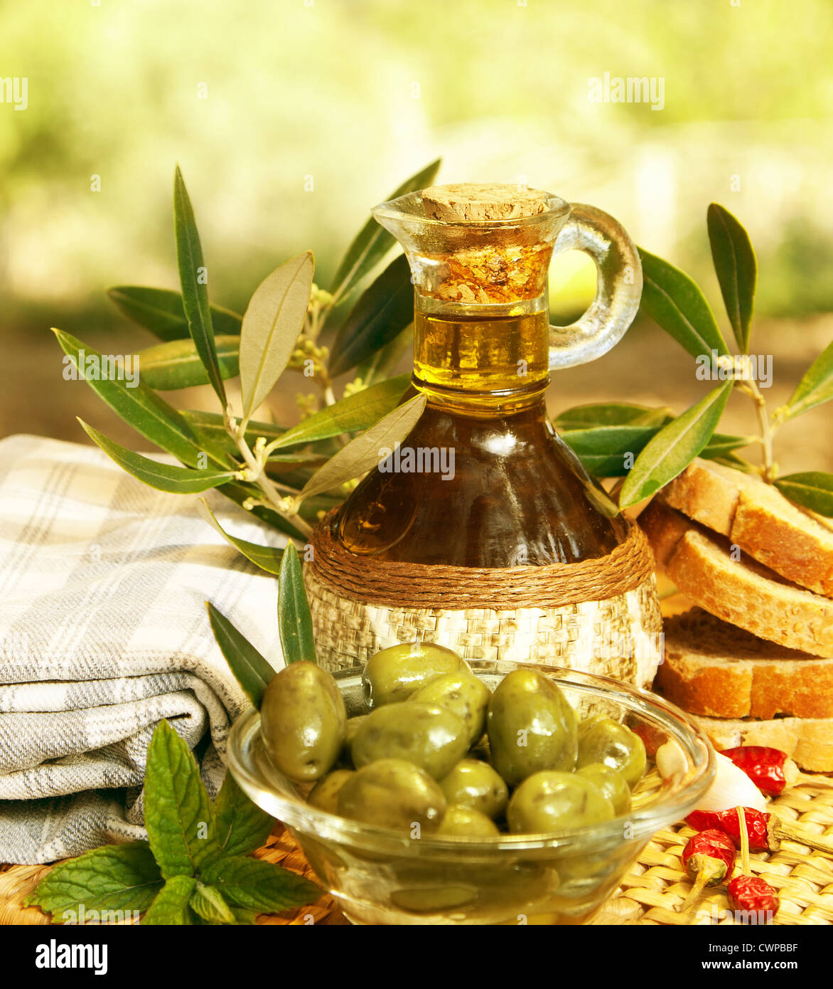 L'huile d'olive dans la bouteille et olives vertes fraîches dans la plaque de verre sur la table, une saine nutrition organique, une cuisine traditionnelle libanaise Banque D'Images