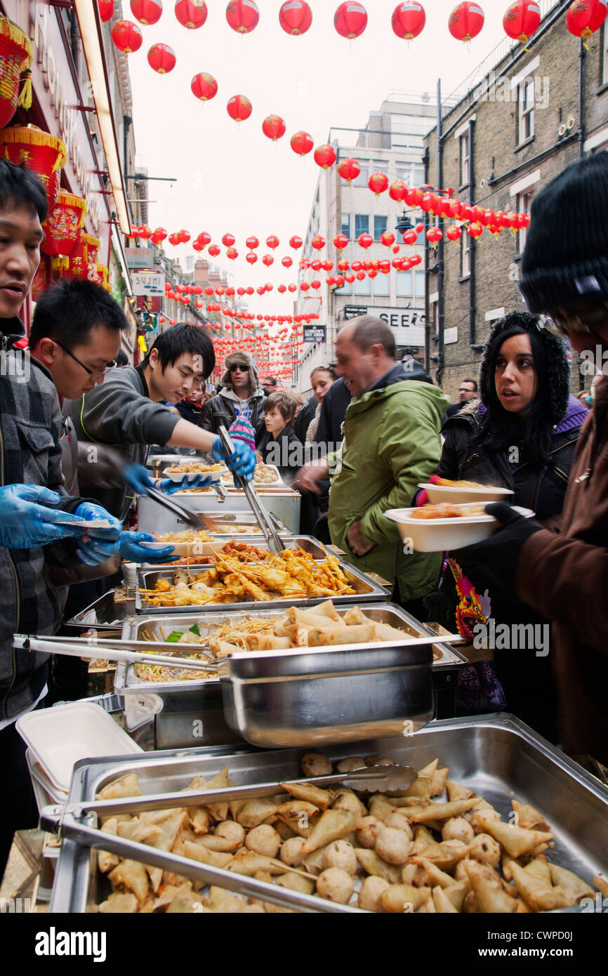 UK. L'Angleterre. Londres. Les personnes à la rue des stands de nourriture chinoise. Les célébrations du Nouvel An chinois. Banque D'Images