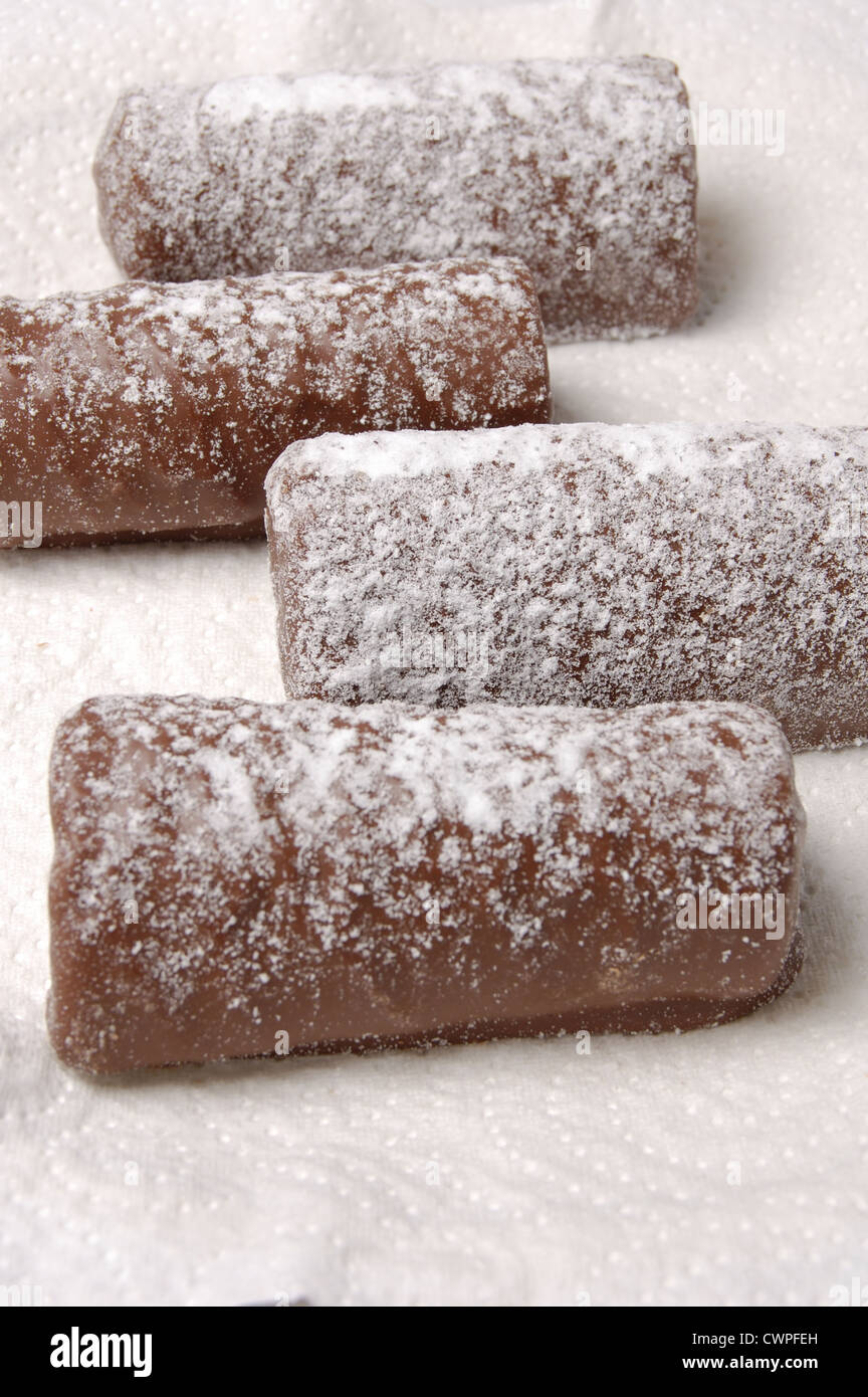 Les journaux au chocolat saupoudrés de sucre glace sur une serviette en papier Banque D'Images