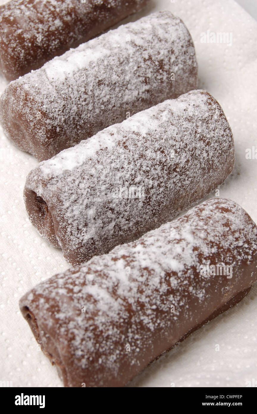 Les journaux au chocolat saupoudrés de sucre glace sur une serviette en papier Banque D'Images