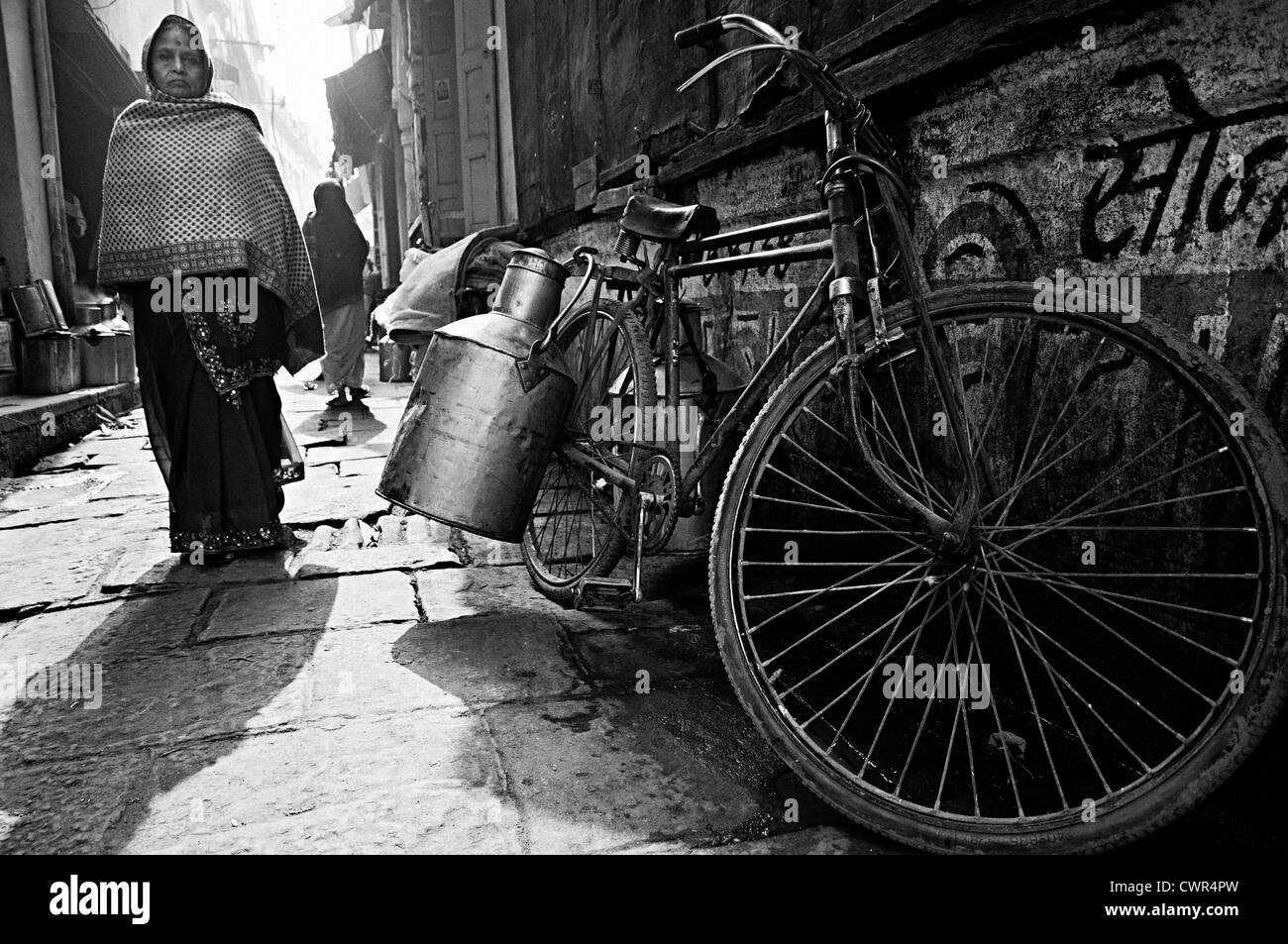 Location du laitier stationnée dans une ruelle et la femme venue. Varanasi, Uttar Pradesh, Inde Banque D'Images