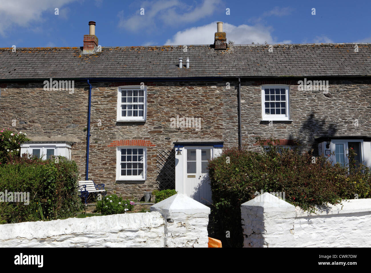 L'extérieur du parc de logements au Royaume-Uni ciel bleu ensoleillé, fisherman's cottages en pierre mitoyenne, St Mawes, Cornwall, UK Banque D'Images