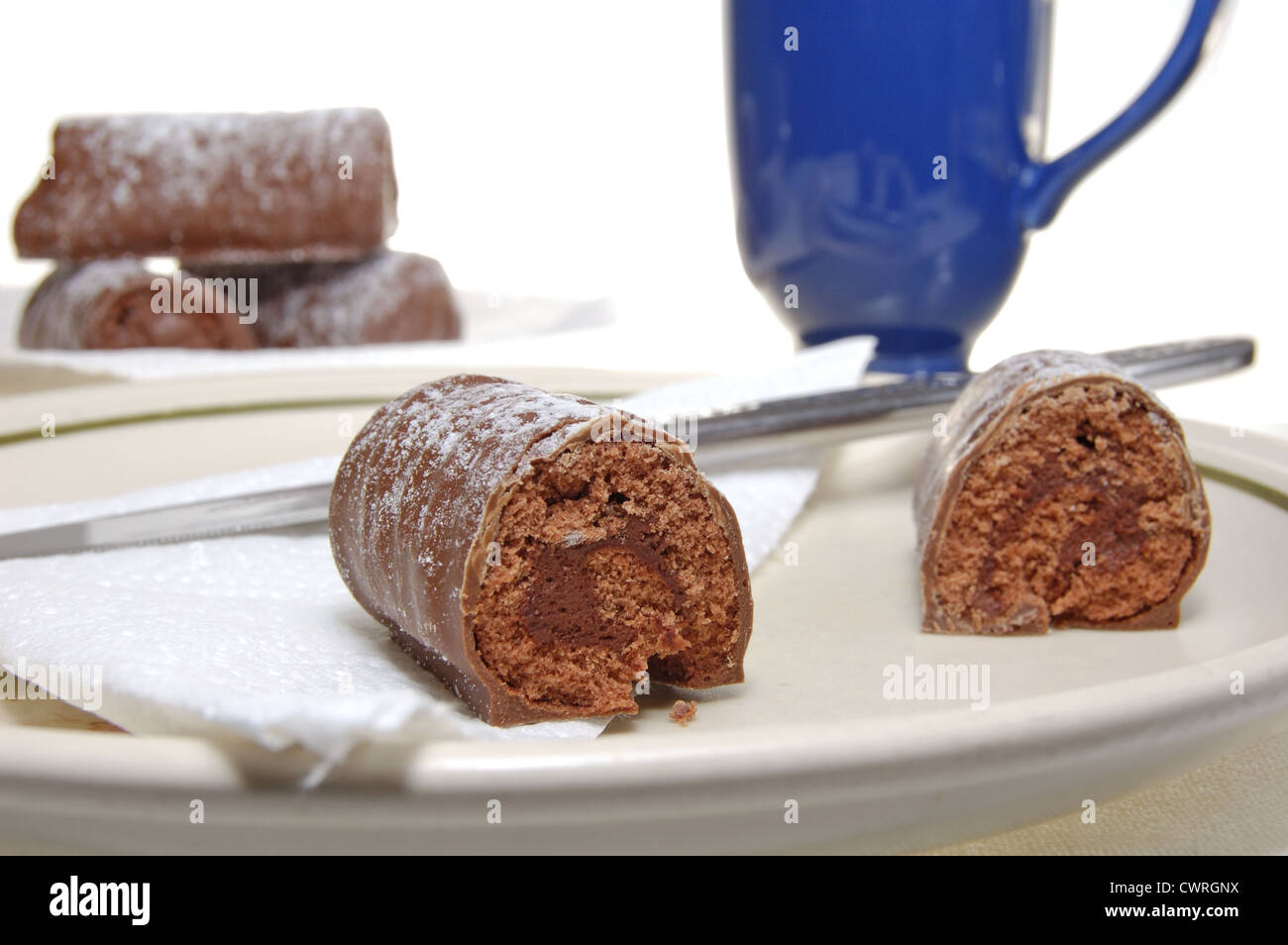 Les journaux au chocolat saupoudrés de sucre glace sur une plaque Banque D'Images