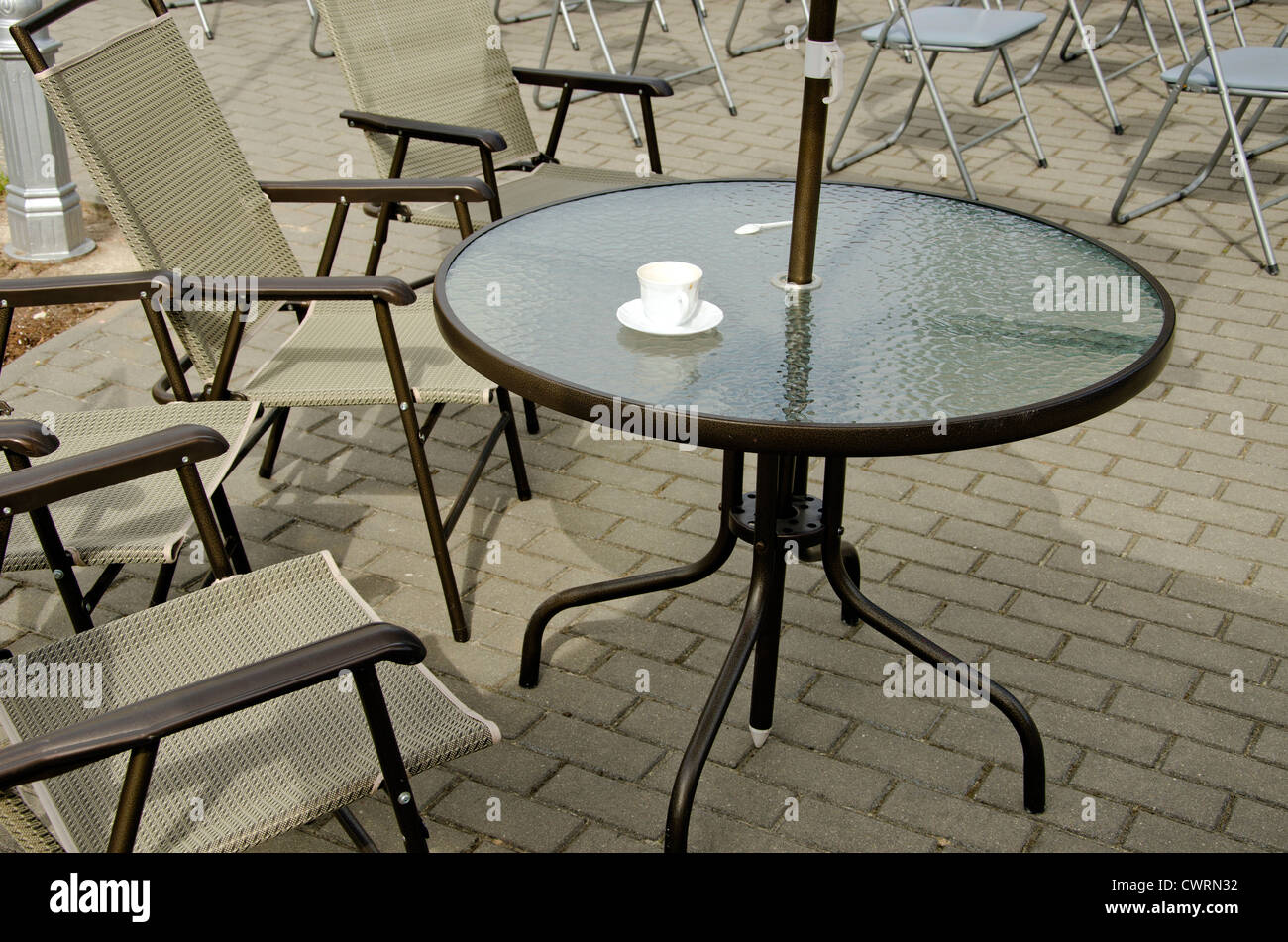 La tasse de café vide sur la table et chaises sur le trottoir. Café en plein air. Banque D'Images