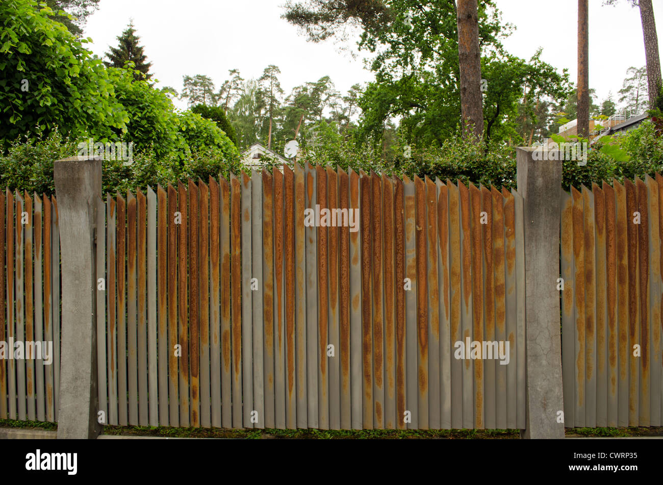 Old rusty steel clôture métallique entouré près de appartement maison jardin. Banque D'Images