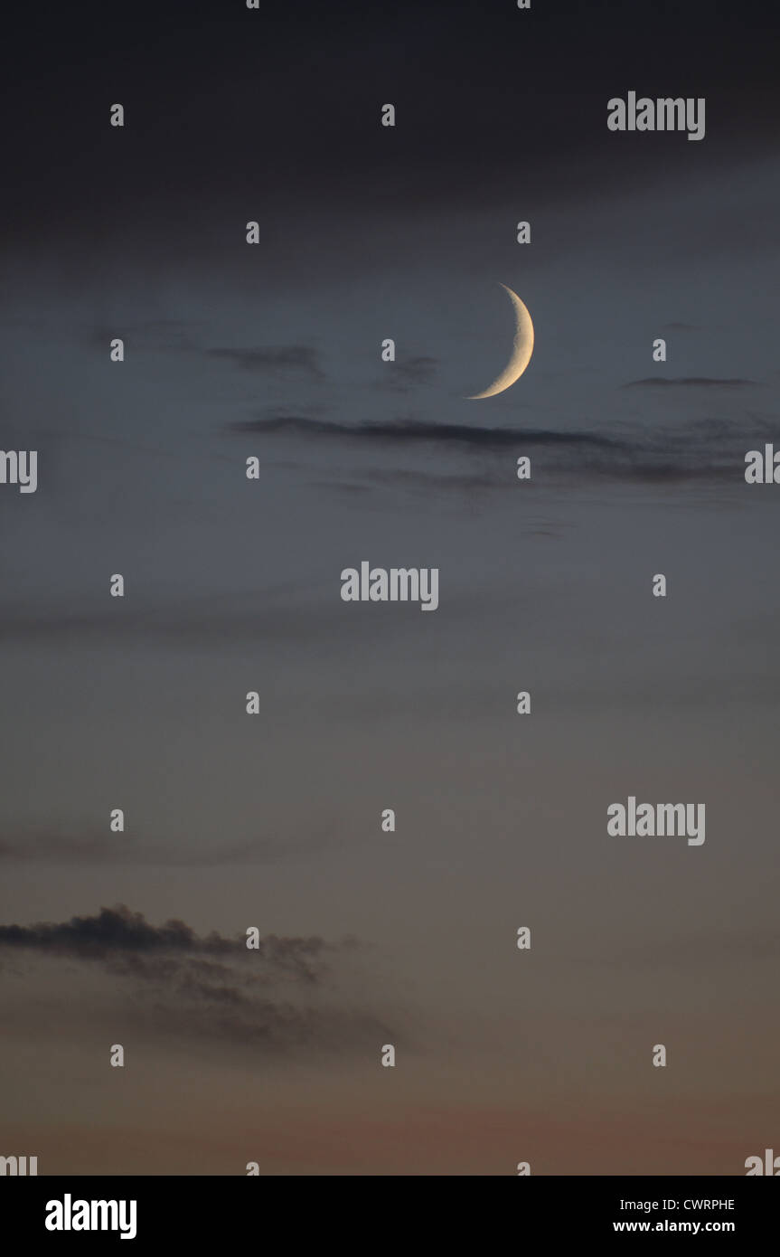 Nouveau croissant de lune et Vénus vu contre l'éclat chaleureux de sunset sky Banque D'Images