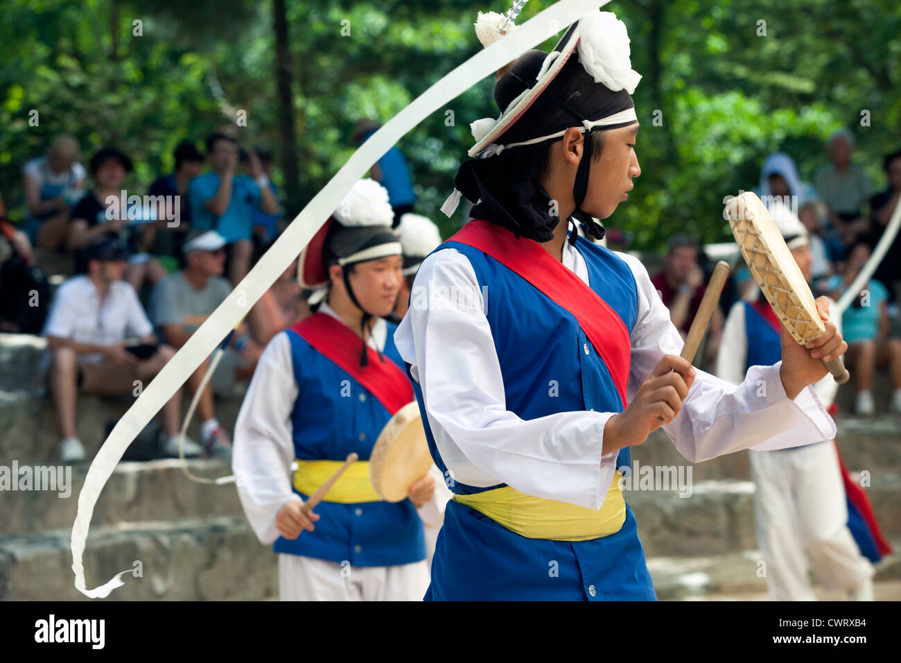 Les agriculteurs coréens danseurs virevoltant au ruban attaché à leur chapeau au Village folklorique coréen à Yongin, Corée. Banque D'Images