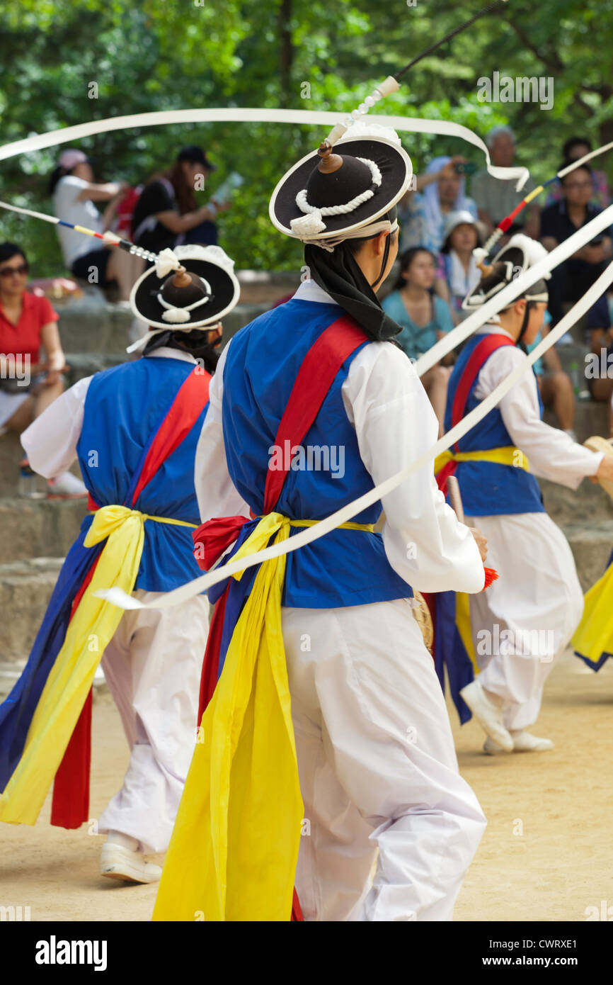 Les agriculteurs coréens danseurs virevoltant au ruban attaché à leur chapeau au Village folklorique coréen à Yongin, Corée. Banque D'Images