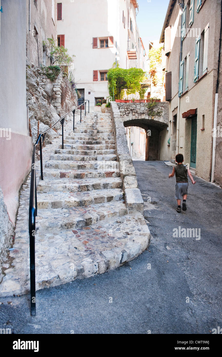 Un jeune garçon marche sur une journée ensoleillée dans une rue de Callas, Provence, France, Europe Banque D'Images