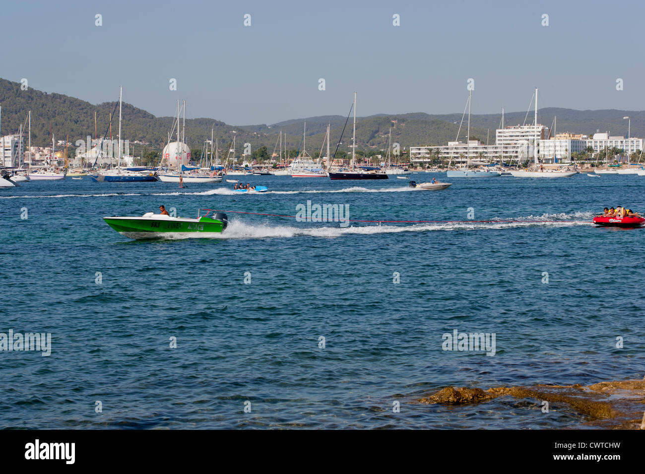 Ville de San Antonio, Ibiza, Espagne avec bateau gonflable de remorquage avec des gens Banque D'Images
