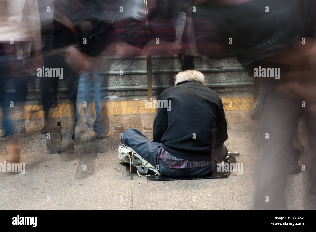 Hong Kong - une personne est à la mendicité pour de l'argent à l'extérieur d'une station de métro. Banque D'Images