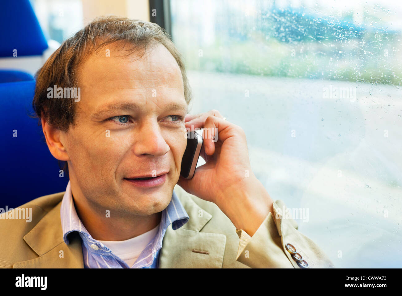 Homme d'affaires sur le téléphone, tout en voyageant par train Banque D'Images