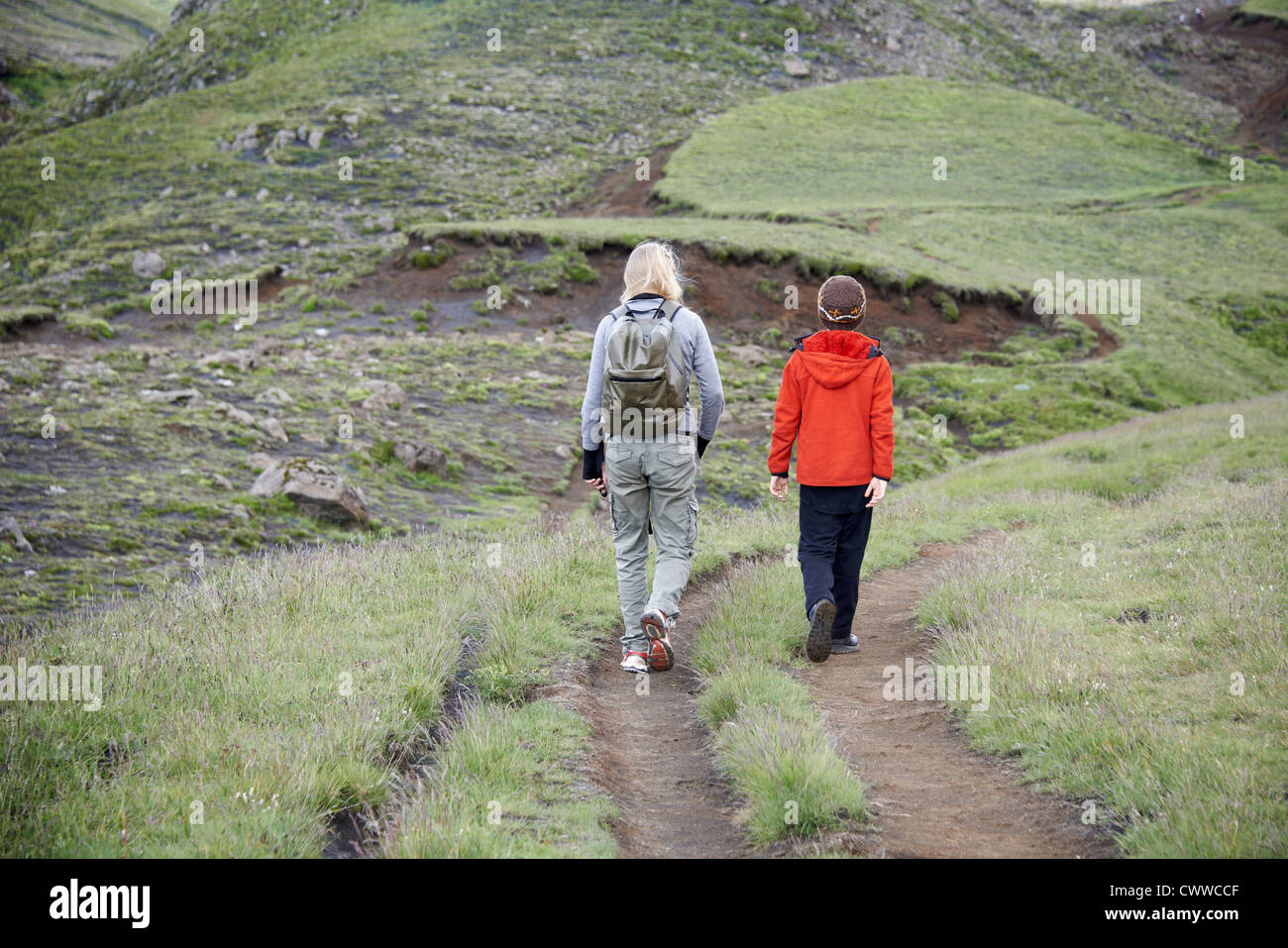 Mère et fille randonnées on hillside Banque D'Images