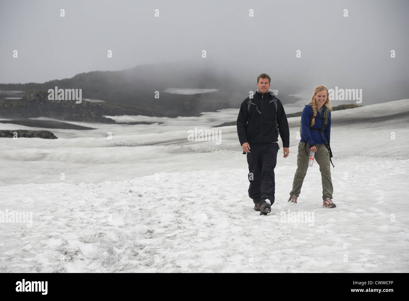 Les Randonneurs marchant dans paysage de neige Banque D'Images