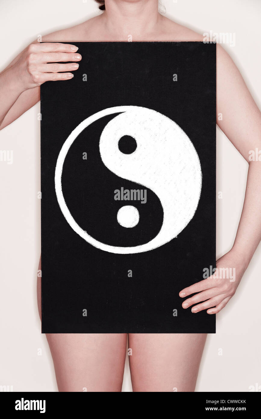 Femme tenant un tableau noir avec un symbole Yin Yang dessiné dessus à la craie. Image Concept Banque D'Images