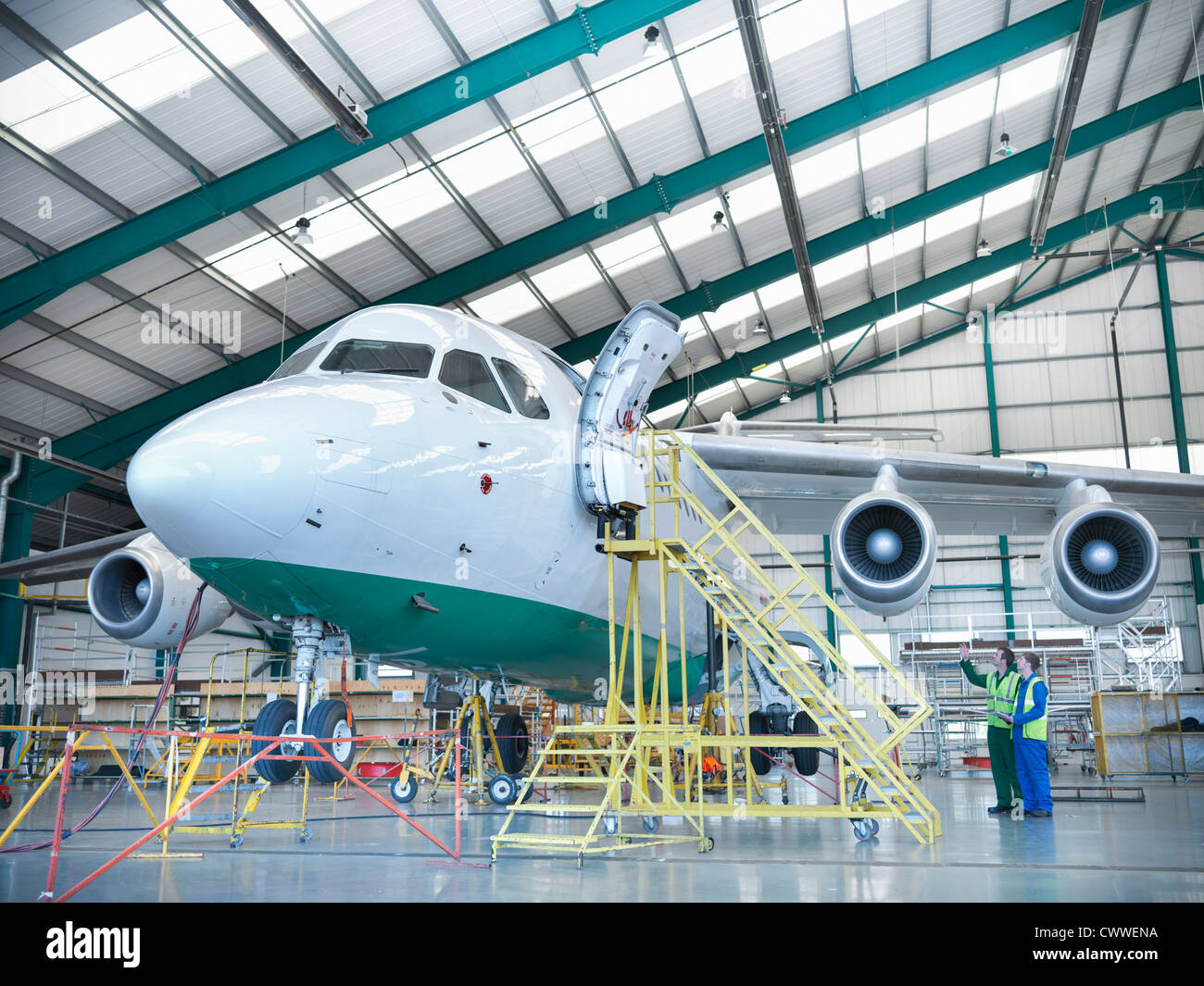 L'inspection des aéronefs à réaction travailleurs in hangar Banque D'Images