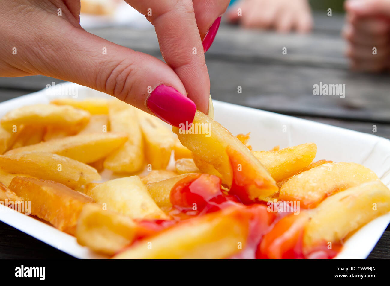 Femme avec des ongles rose eating chips Photo Stock - Alamy