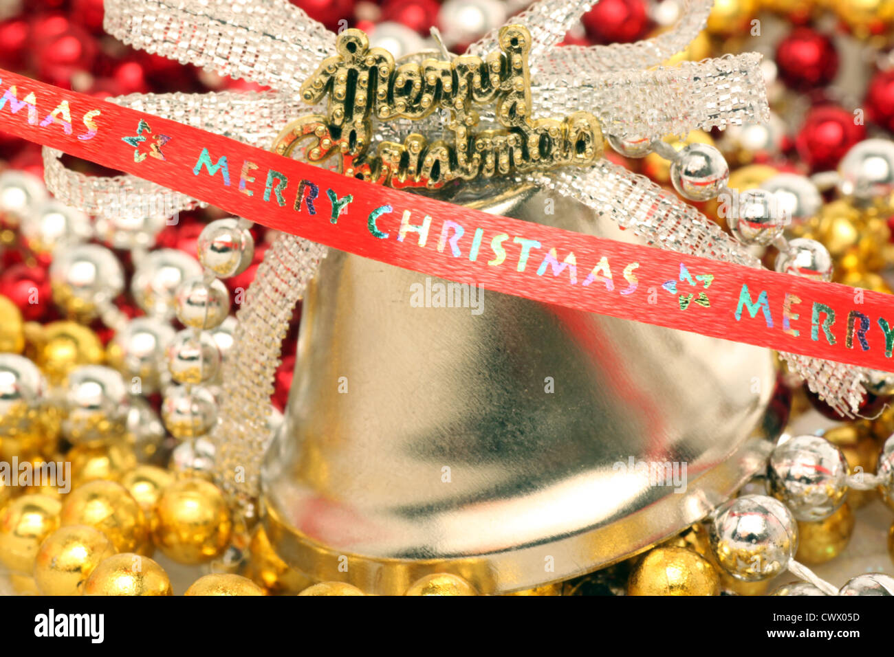 Joyeux Noël ruban en face de Bell et de perles Banque D'Images