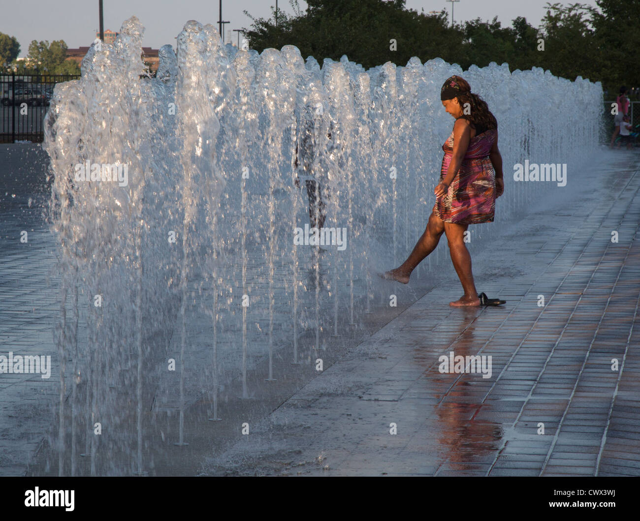 Detroit, Michigan - une femme sort la toe dans une fontaine sur le Detroit de Riverwalk. Banque D'Images