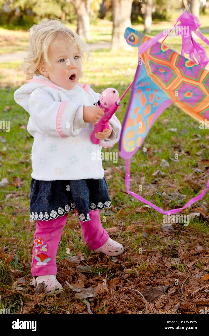 Petite fille jouant avec un cerf-volant rose. Banque D'Images