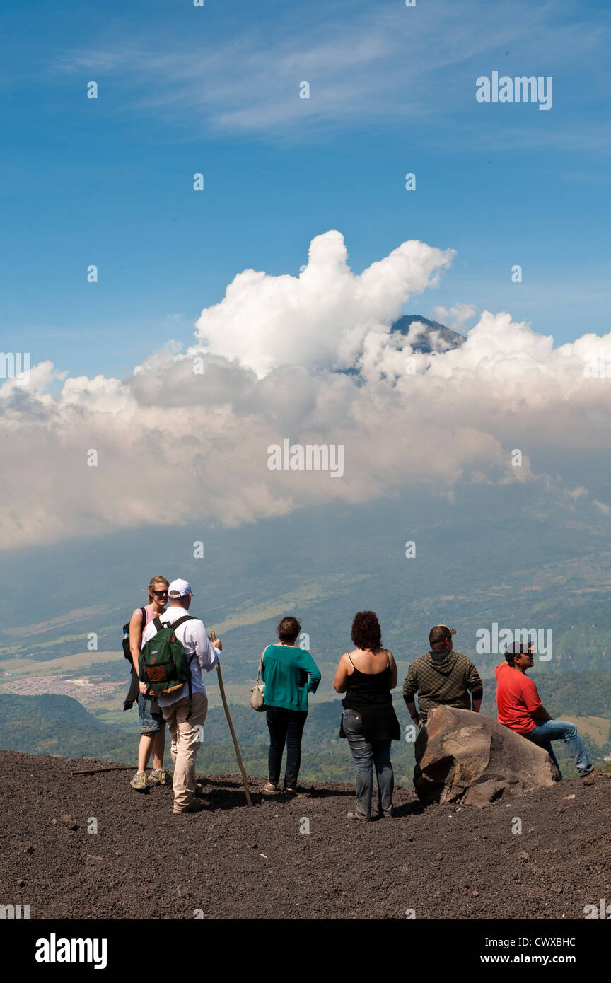 Les randonneurs sur le volcan Pacaya, avec Fuego Volcan de distance Antigua, Guatemala, Amérique centrale. Banque D'Images