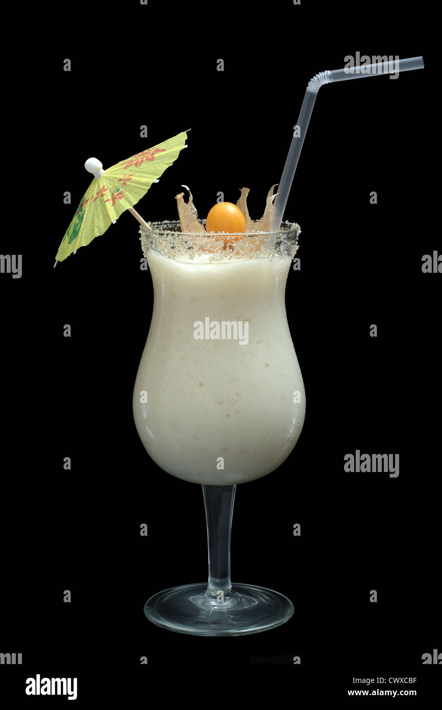 Smoothie blanc guanabana dans verre à cocktail décoré d'un parasol en papier, une paille à boire et un fruit physalis Banque D'Images