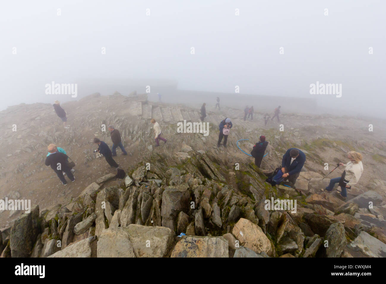 Les marcheurs dans la brume sur le sommet du Snowdon, avec Hafod Eryri en arrière-plan. Banque D'Images