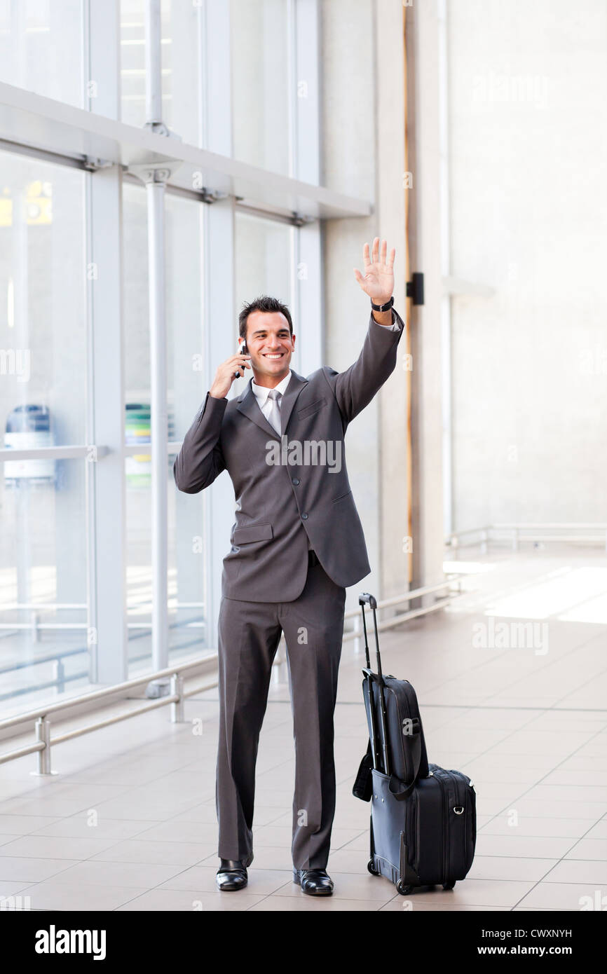 Young businessman waving au revoir à l'aéroport Banque D'Images
