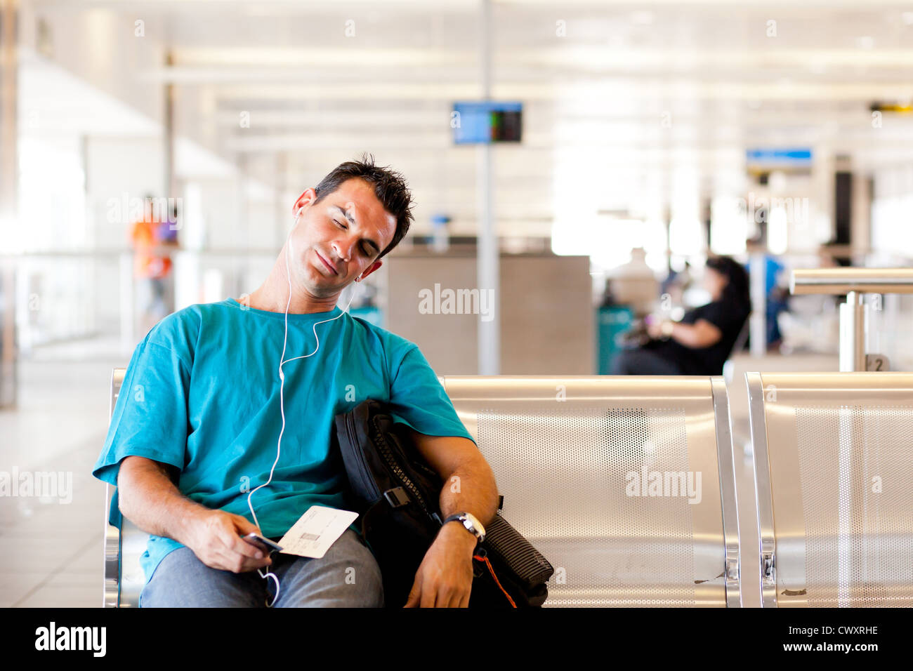 Jeune homme fatigué traveler sleeping in airport Banque D'Images