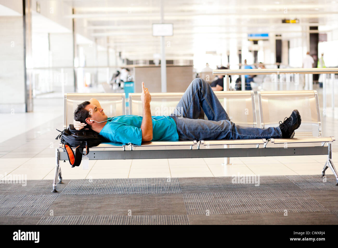 Jeune homme couché sur des chaises de l'aéroport et de repos Banque D'Images