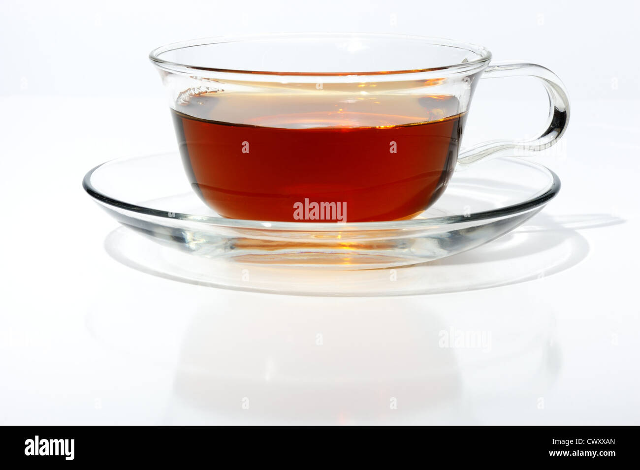 Le thé noir dans une tasse en verre, sur un fond blanc isolé. Banque D'Images