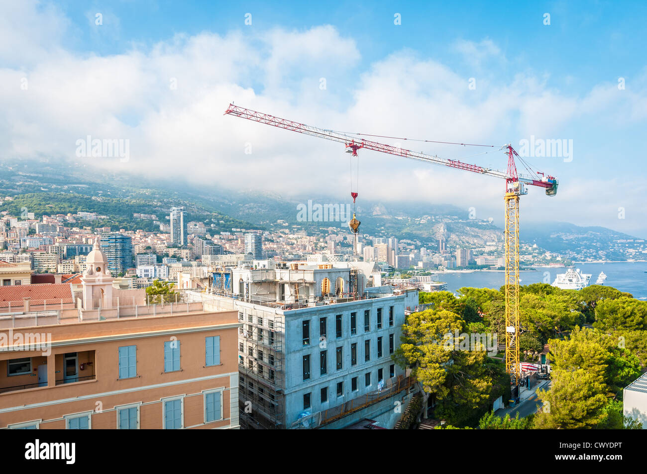 Paysage urbain de la ville de Monte Carlo avec de nouveaux bâtiments et crane en premier plan et les montagnes, de la mer et du ciel avec des nuages en arrière-plan. Banque D'Images