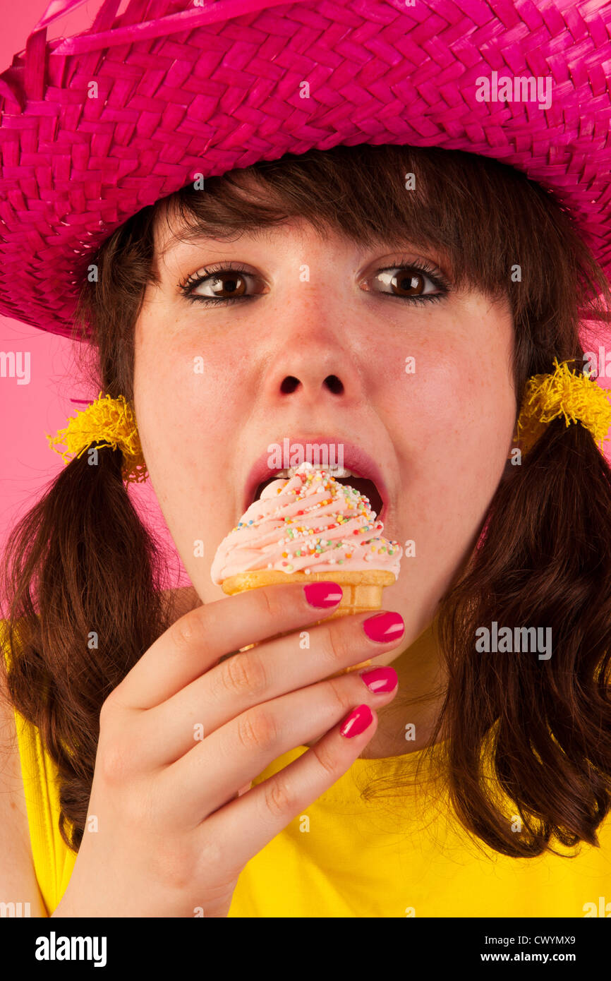 Douce jeune fille en jaune et rose avec icecream Banque D'Images