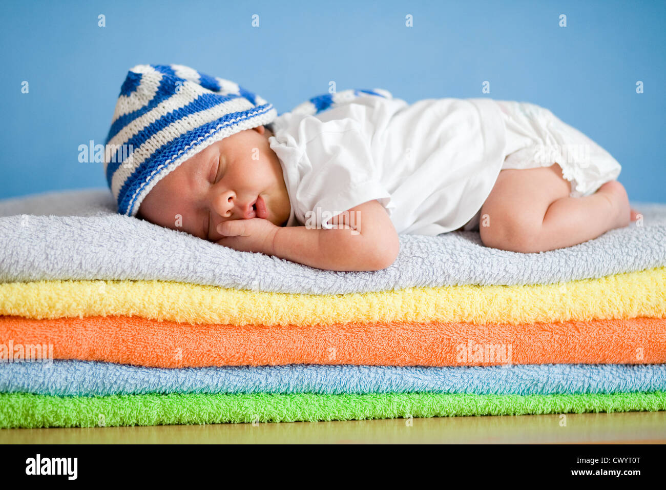 Dormir bébé nouveau-né sur la pile de serviettes colorées Banque D'Images