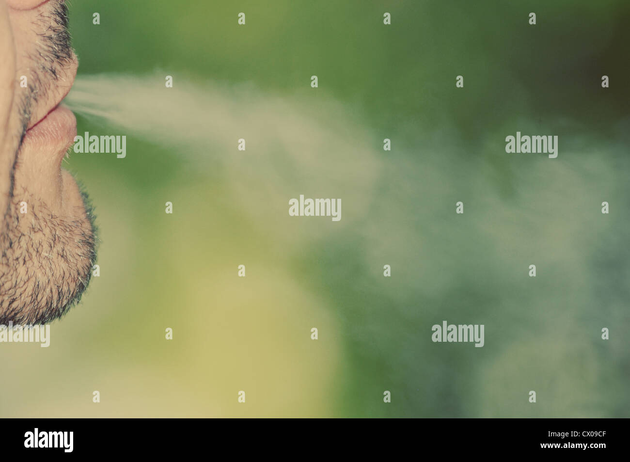 Exhalant la fumée de cigarette. La tonalité de l'image. Banque D'Images