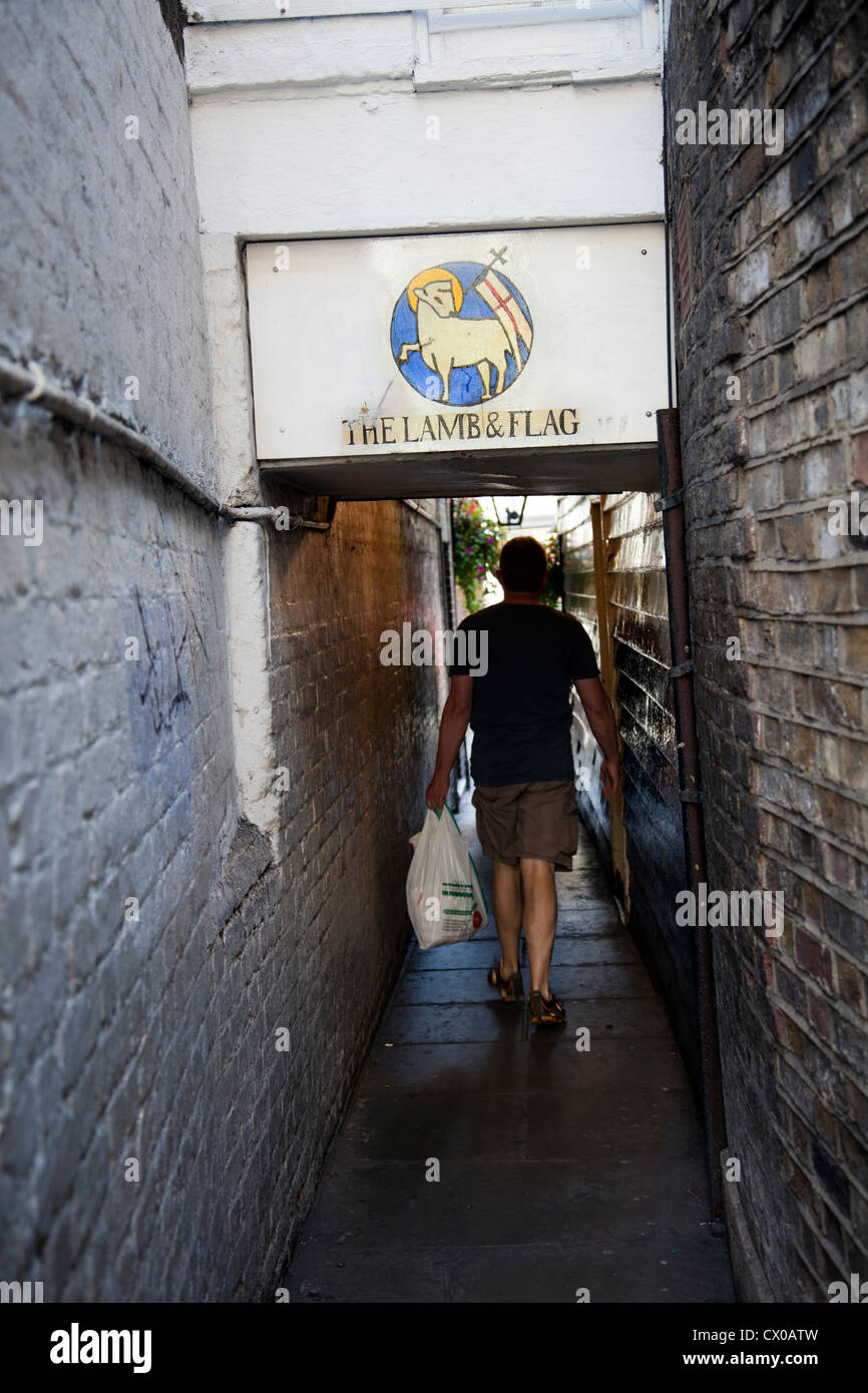 Homme marchant par Ruelle de Lamb & Flag pub à Covent Garden - Londres UK Banque D'Images