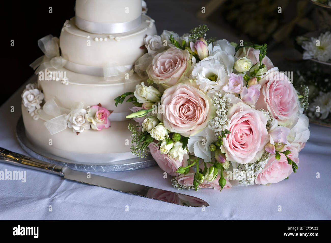 Mariage bouquet de roses roses et blanches avec le gâteau de mariage Banque D'Images