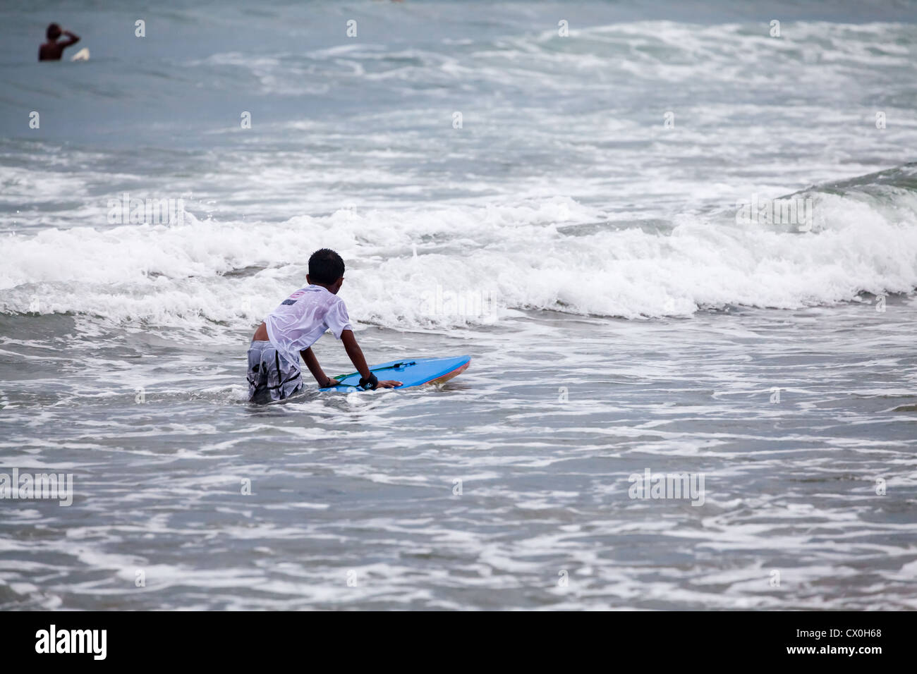 Surfer sur la plage de Kuta à Bali Banque D'Images