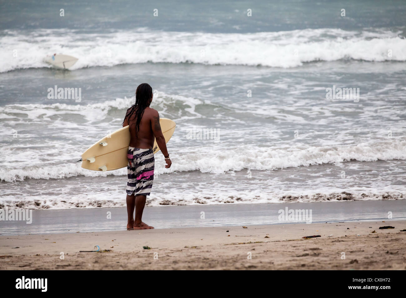 Surfer sur la plage de Kuta à Bali Banque D'Images