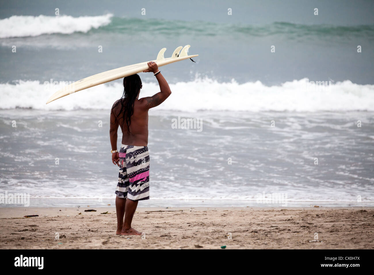 Surfer sur la plage de Kuta à Bali Banque D'Images