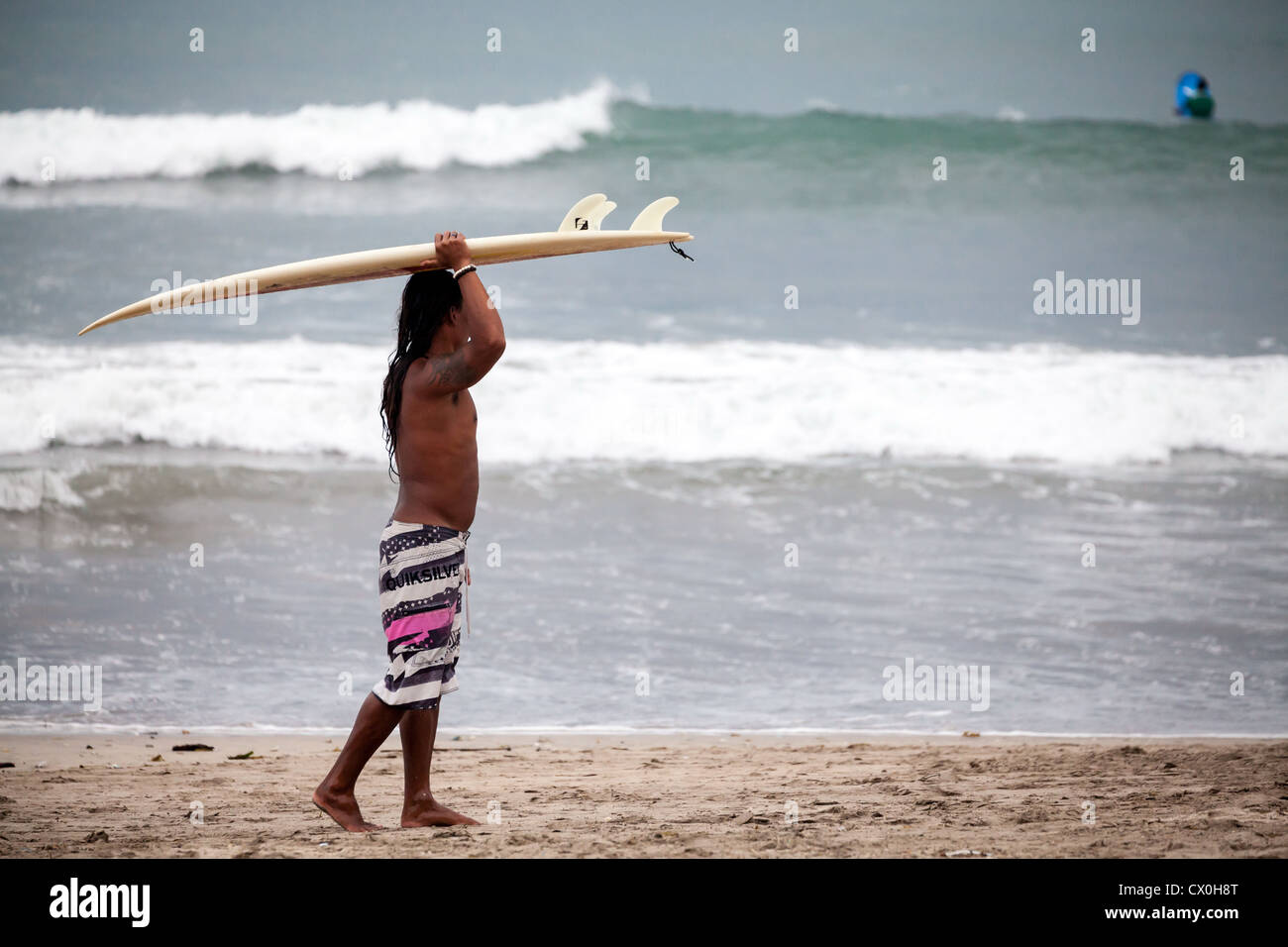 Surfer sur la plage de Kuta à Bali Banque D'Images