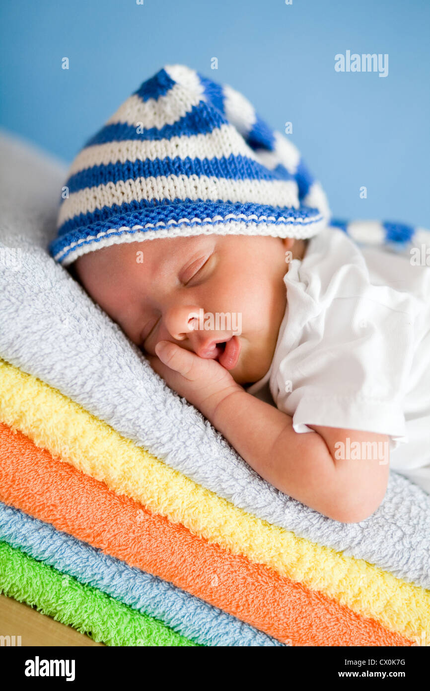 Bébé nouveau-né sommeil closeup portrait sur la pile de serviettes colorées Banque D'Images