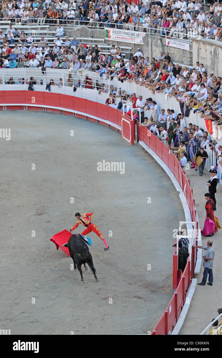 Regardez l'auditoire à l'aide de matador cape rouge pour provoquer black bull en corrida Corrida dans l'arène romaine Arles France Banque D'Images