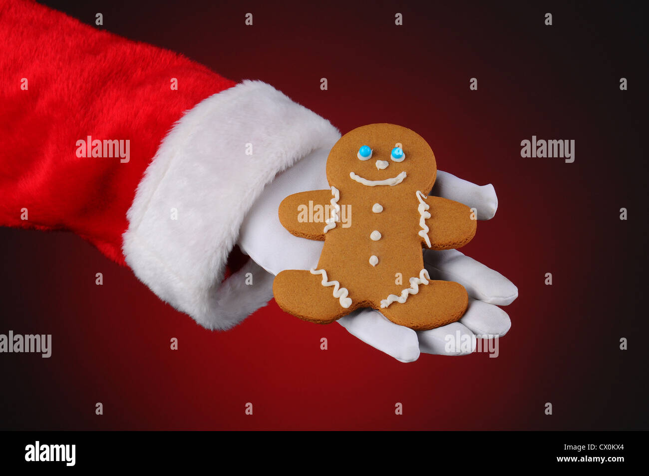 Santa Claus holding a Gingerbread Man cookie dans la paume de sa main. Banque D'Images