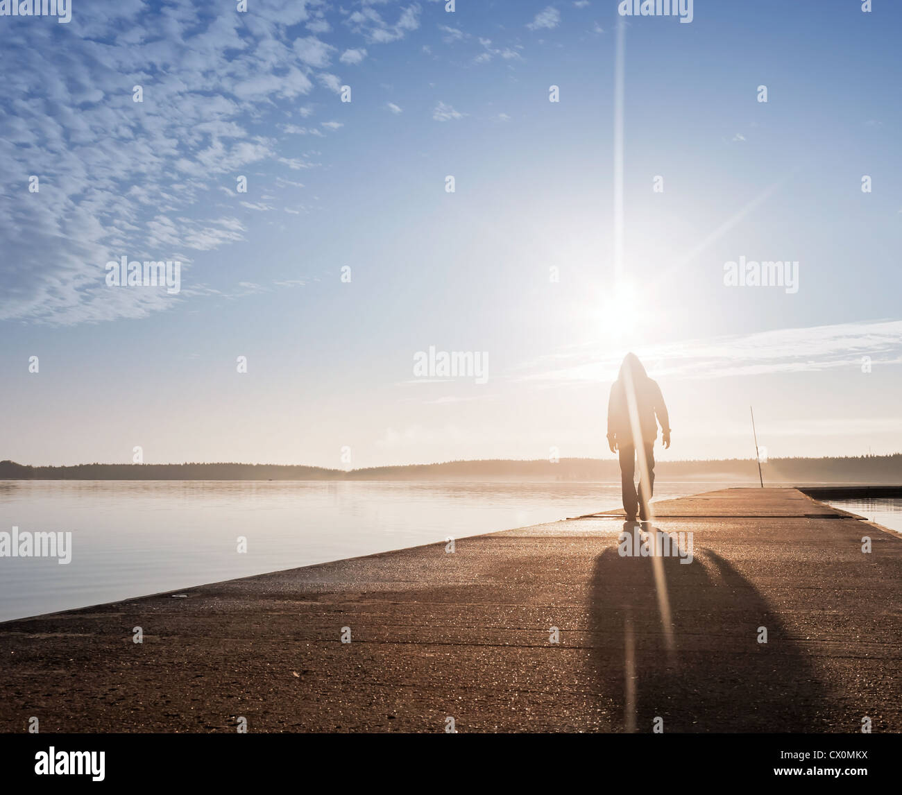 Un homme va sur les piliers de béton dans la lumière du soleil Banque D'Images