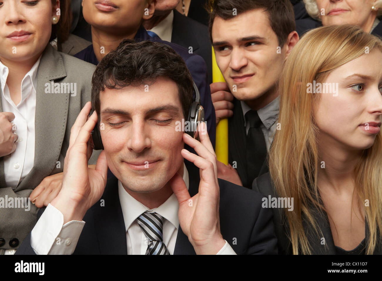 Businesswoman wearing headphones on Subway train Banque D'Images