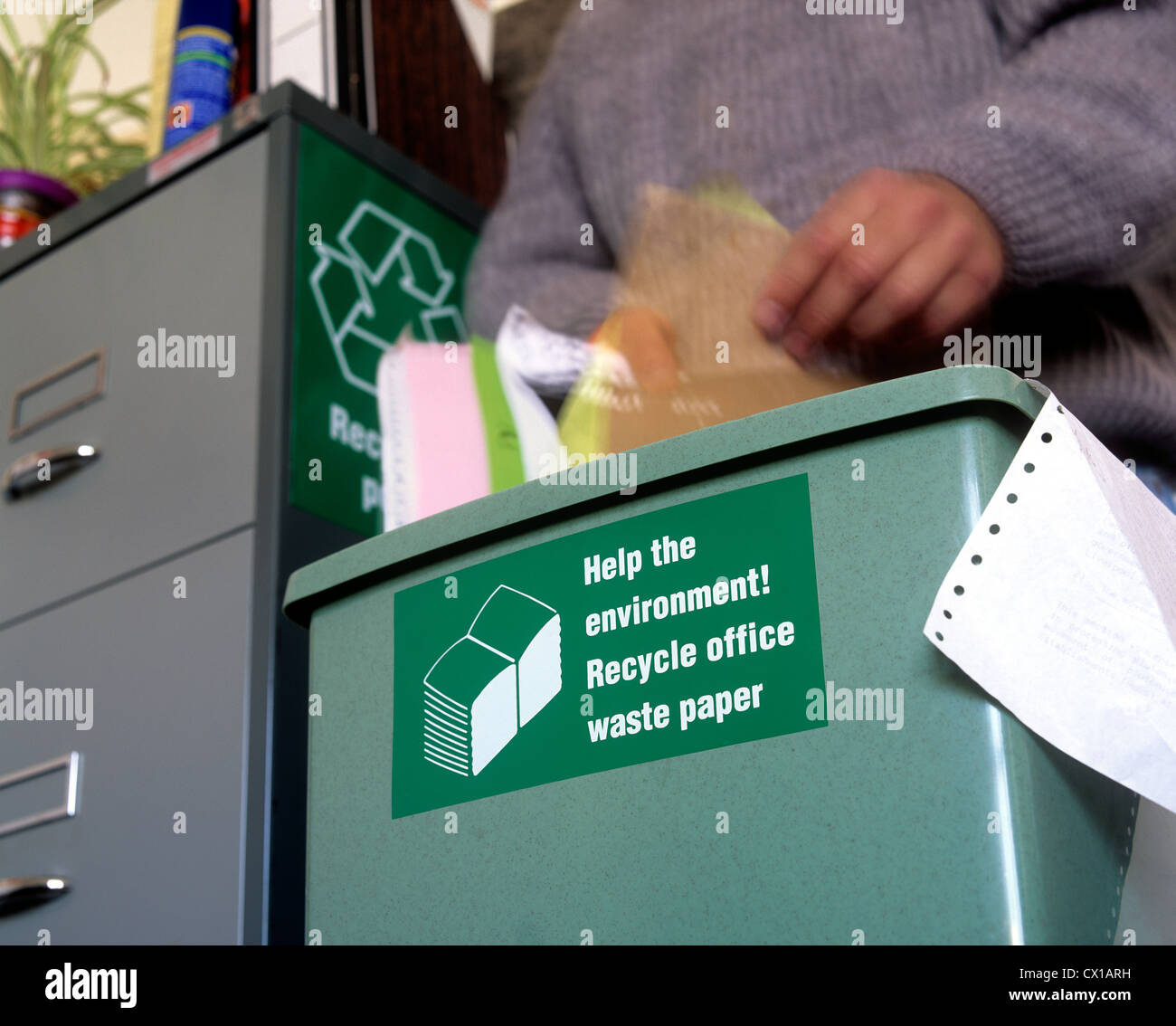 Office worker mettre les déchets de papier dans un bac de recyclage. Banque D'Images